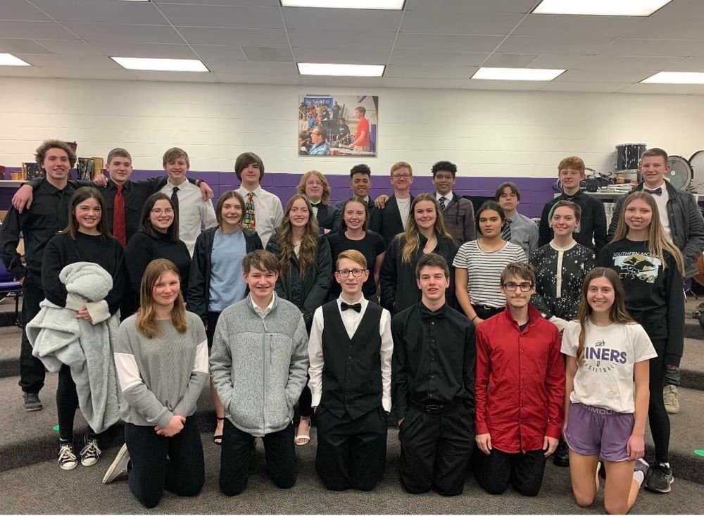 high school band and choir posing for picture in classroom