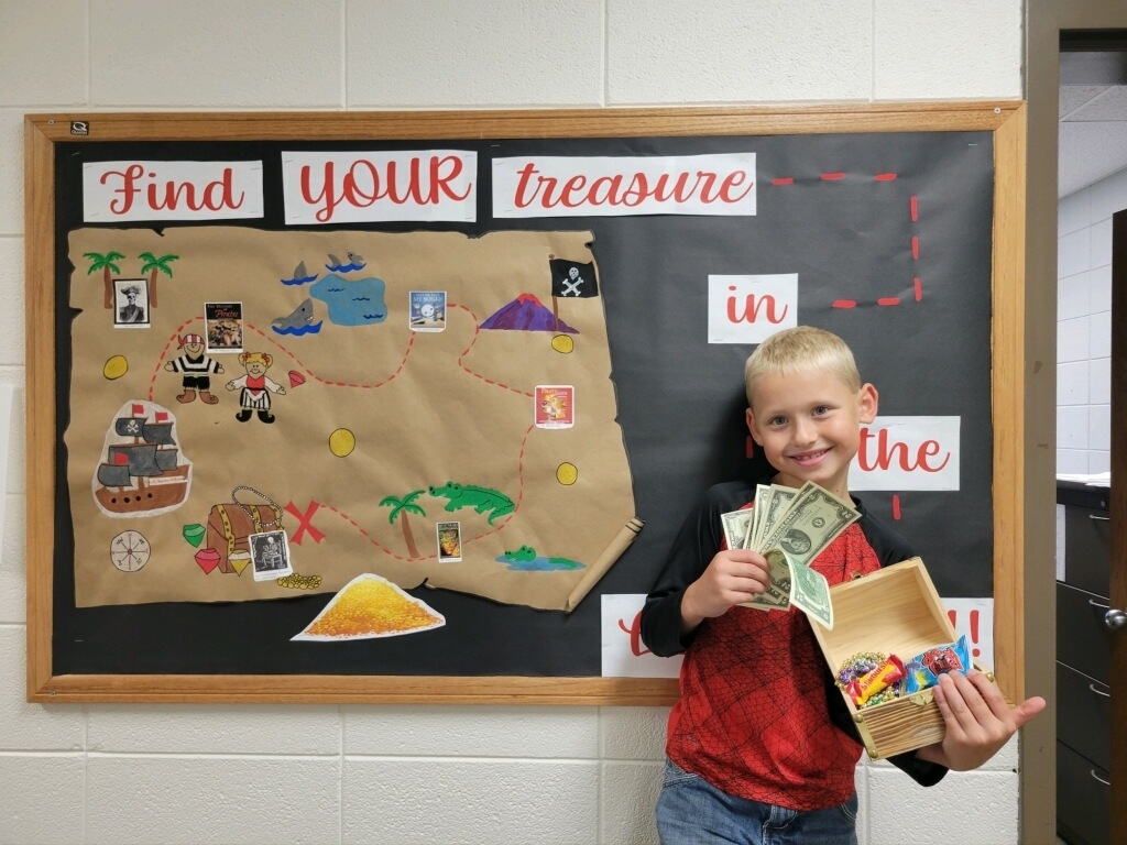 child showing open treasure chest and smiling